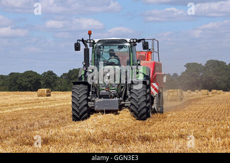 Chessington, Surrey, UK. 6th August 2016. Making hay while the sun shines at Chessington, Surrey, England. A warm day with blue skies make perfect conditions for harvesting the wheat and baling up the hay. Credit:  Julia Gavin UK/Alamy Live News Stock Photo