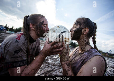 Woellnau, Germany. 06th Aug, 2016. Cecile Ruediger (L) and Sandra Schaefer, players with the 'Hallzig Fighters' from Eilenburg, kiss the ball at the German Championship in Mud Soccer in Woellnau, Germany, 06 August 2016. The winners of the playful championship qualify for the World Championship in Finland. Photo: ALEXANDER PRAUTZSCH/dpa/Alamy Live News Stock Photo