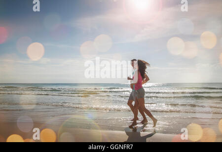 Caucasian couple jogging on beach Stock Photo