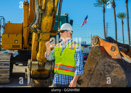 Caucasian construction worker using walkie-talkie Stock Photo