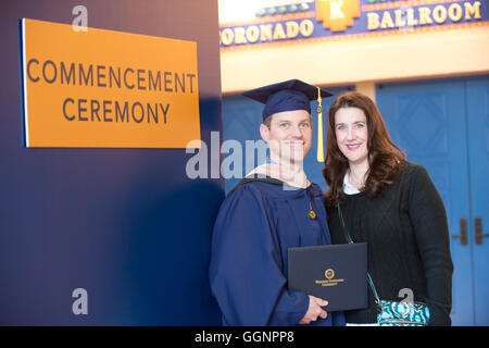 Graduate of Western Governors University poses with friend after commencement ceremony in Orlando, Florida. Stock Photo