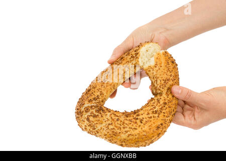 Female hands breaks a bagel, isolated on white background Stock Photo