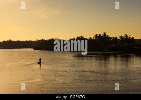 Fisherman is fishing in sunrise at Thu Bon river, Cua Dai, Quang Nam, Vietnam. Stock Photo