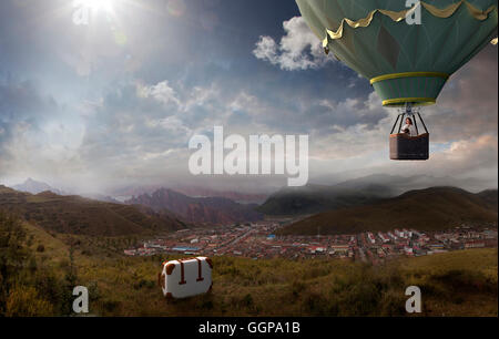 Caucasian woman in hot air balloon forgetting suitcase Stock Photo