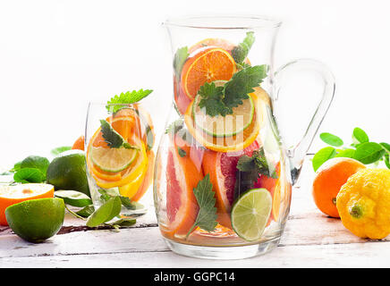Pitcher and glass with citrus fruits and mint leaves. Stock Photo