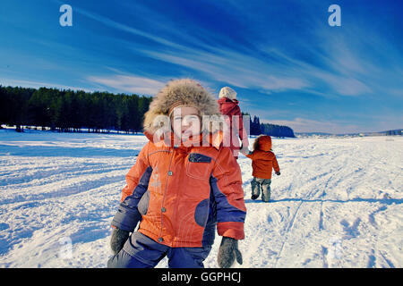 Mother and sons walking in snowy remote field Stock Photo