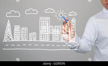 Hand of businessman drawing graphics a symbols geometric shapes of city and skyscraper to buildings concept in business and have Stock Photo