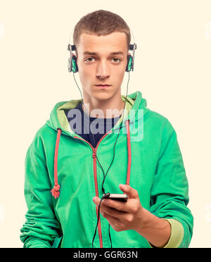 Handsome guy using phone with headphones. Toned photo. Stock Photo