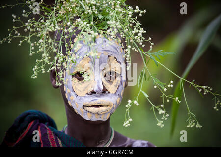 Young girl from Suri tribe with traditional bodypainting and flowers ornament. Stock Photo