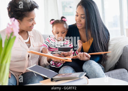 Black multi-generation family looking at photo album Stock Photo