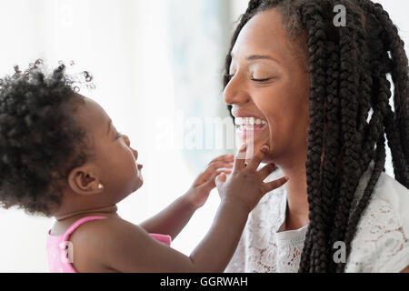 Black woman playing with baby daughter Stock Photo