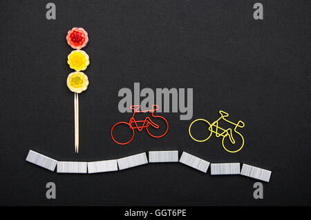 Paper clips in a form of bicycle near the light of sweets. Safety for cyclists on the road. Stock Photo