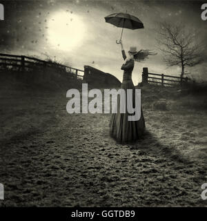 young woman like marry Poppins  with umbrella standing in fields Stock Photo