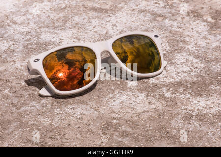 white sunglasses lying on the stone surface texture Stock Photo