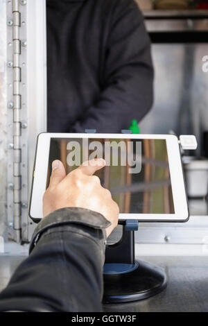 Man paying at food cart using digital tablet Stock Photo