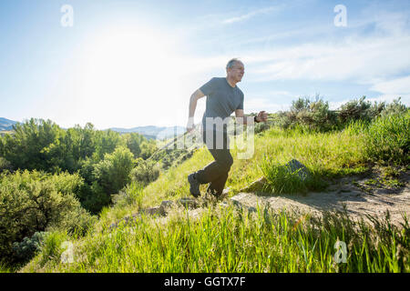 Caucasian man running up staircase on hill Stock Photo