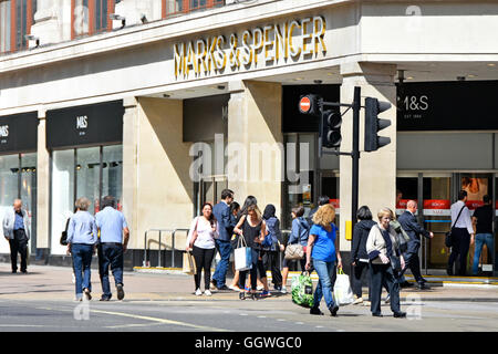 West End shoppers in Oxford Street outside entrance to Marks and Spencer flagship Marble Arch shopping department store in London England UK Stock Photo