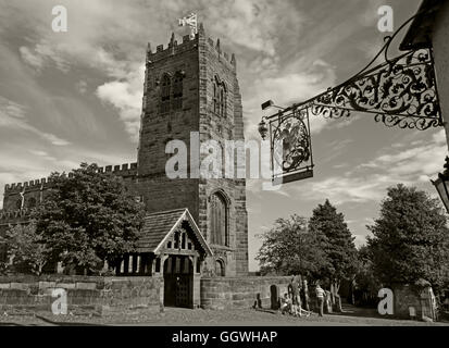 George and Dragon wrought iron sign and St Marys Church,Great Budworth,Cheshire,England, UK - Monochrome Sepia Stock Photo