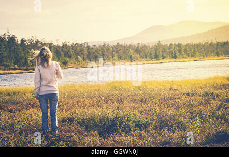 Woman Traveler walking alone Travel Lifestyle concept Summer vacations outdoor lake and mountains on background
