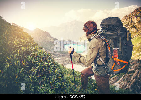 Man Traveler with big backpack mountaineering Travel Lifestyle concept lake and mountains on background Summer extreme vacations Stock Photo