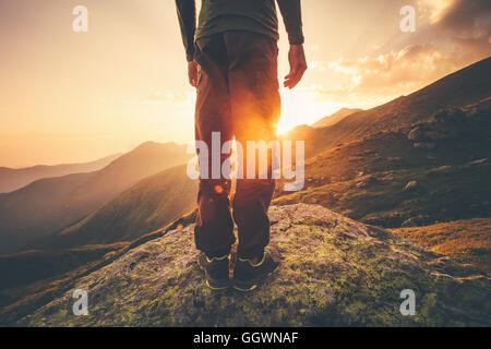Young Man Traveler feet standing alone with sunset mountains on background Lifestyle Travel concept outdoor Stock Photo
