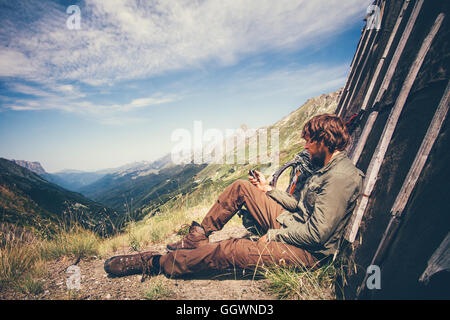 Man Traveler with navigator tracker relaxing alone Travel Lifestyle concept mountains and clouds on background Summer adventure Stock Photo