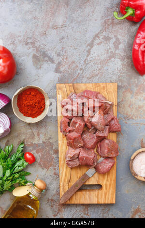 Chopped raw meat with vegetables and herbs, ready to cook, Top view, blank space above Stock Photo