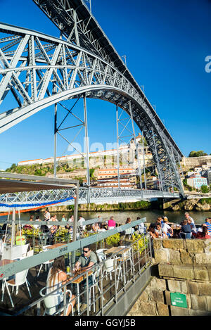 outdoor terrace bar cafe and landmark bridge in ribeira riverside area of porto portugal Stock Photo