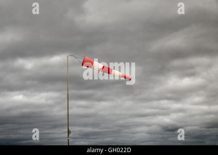 windsock on cloudy sky background in windy weather indicate the local wind direction Stock Photo