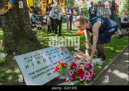 London, UK. 6th August 2016. Kate Hudson of CND lays flowers at  the commemorative cherry tree at the CND ceremony in memory of the victims, past and present on the 71st anniversary of the dropping of the atomic bomb on Hiroshima and the second atomic bomb dropped on Nagasaki three days later. Peter Marshall/Alamy Live News
