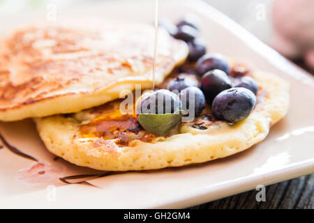 Tasty Pancakes closeup with a blueberries and maple syrup garnish. Stock Photo