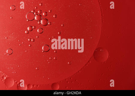 Abstract of red oil drops on water. Light is in the upper left corner Stock Photo