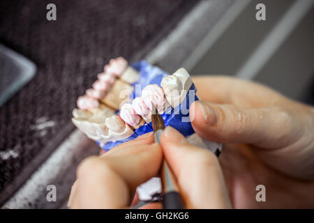 Dental technician working in dental laboratory Stock Photo