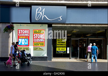Two young women walking past branch of BHS, British Home Stores, holding closing down sale, Middlesborough, North Yorks, England Stock Photo