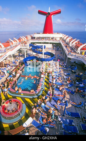 The top deck of a Carnival Cruise Ship on a  Carribean cruise with lots of passengers near the pool. Stock Photo