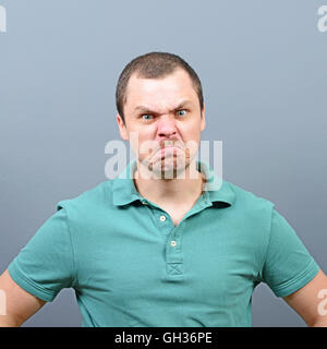 Portrait of a mad looking man against gray background Stock Photo