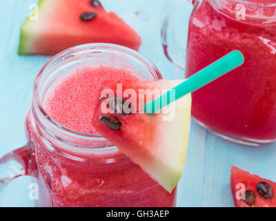 Watermelon smothie and slices on blue background Stock Photo