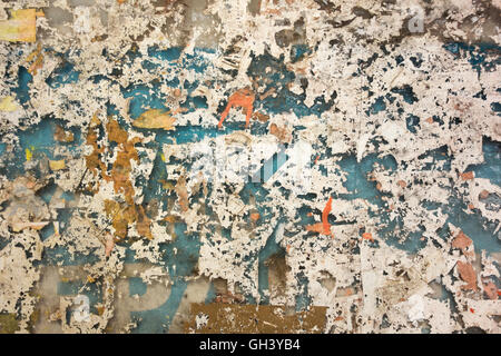 Colorful torn posters on old wall. Grunge textures and backgrounds Stock Photo