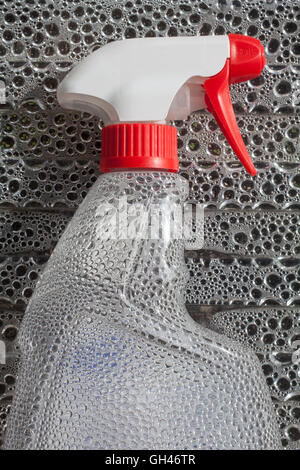 Transparent spray cleaner bottle isolated on water drops Stock Photo