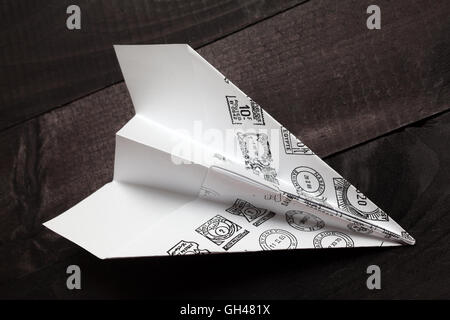 Paper airplane with mail stamps on black background Stock Photo