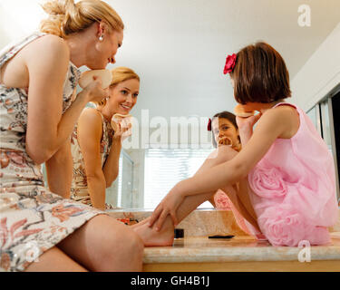 Mother and Daughter Having Fun Together While Applying Make Up in the Bathroom Stock Photo