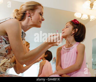 Mother and Daughter Interact Together While Applying Make Up in the Bathroom Stock Photo