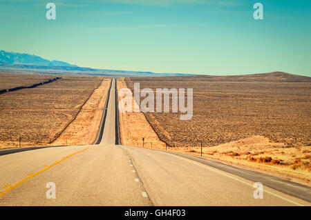 Long straight strech of US highway 287 through ranch country in central Wyoming, USA. Retro instagram look. Stock Photo