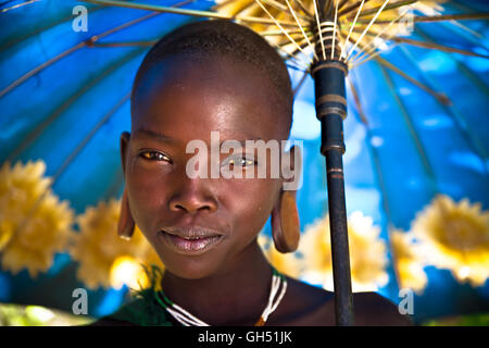 Young girl from Suri tribe with umbrella. Stock Photo