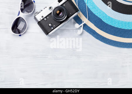 Beach accessories. Camera, hat and sunglasses on wooden background. Top view with copy space Stock Photo