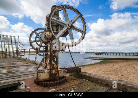 The slowly decaying piers at Shotley Gate in Suffolk old crane on harbour Stock Photo