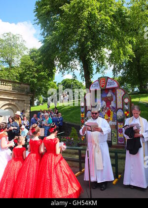 The Rev John Hudghton blessing a Magna Carta themed well dressing at St Ann's Well, Buxton, Derbyshire, watched by rose queens Stock Photo