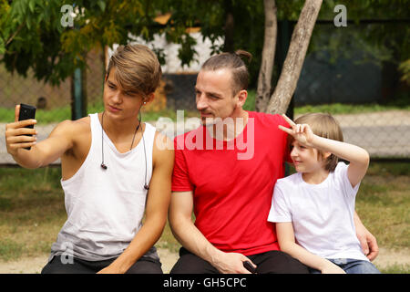 father and two sons posing for photo selfie Stock Photo