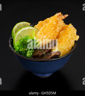 Shrimp Tempura with fresh salad of seaweed, lemons and mushrooms in a bowl Stock Photo