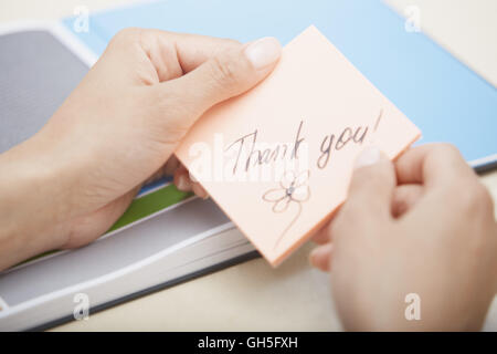 Woman holding sticky note with Thanks text Stock Photo - Alamy